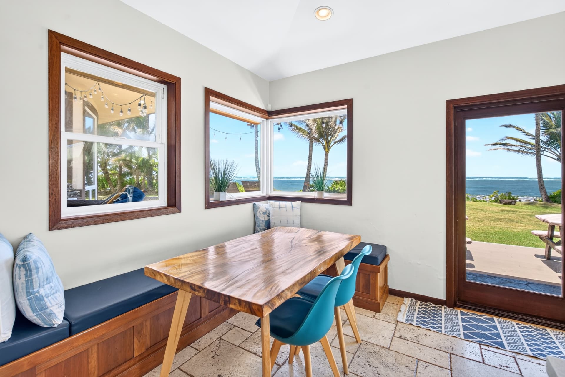 Coastal Oahu dining nook with wide ocean views through multiple windows