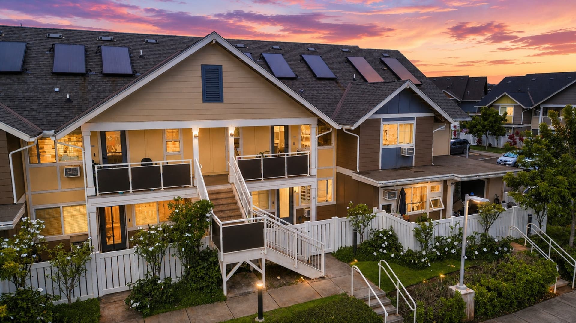 Aerial twilight view of Oahu residences beneath a colorful sunset sky