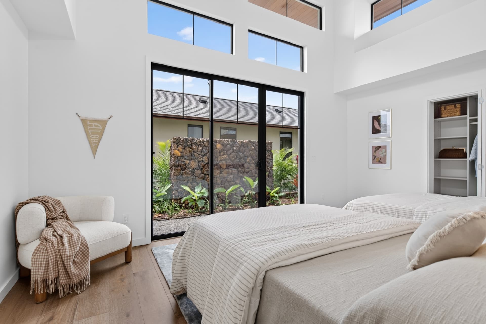 Bright Oahu bedroom with high windows and a private tropical garden outlook
