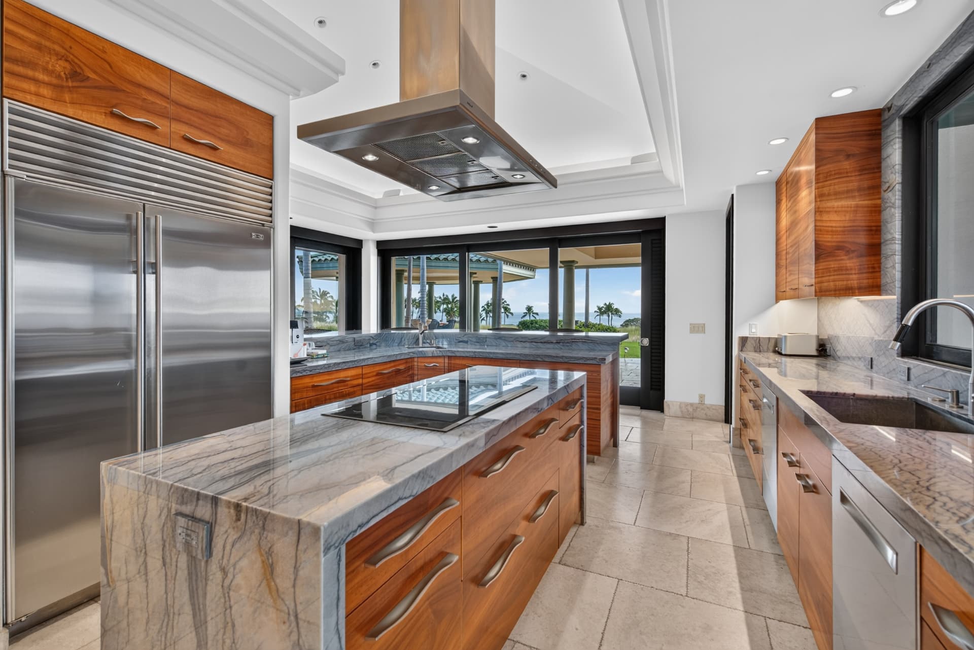 Luxury Oahu kitchen with wood cabinetry, marble counters, and ocean views