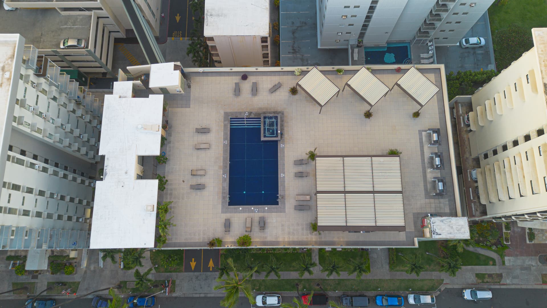 Top-down aerial view of a Honolulu rooftop pool and gathering spaces
