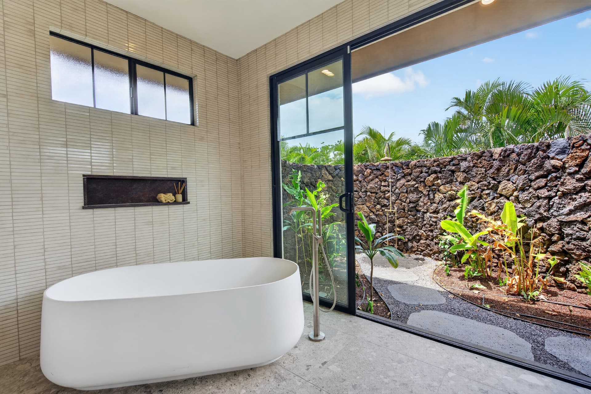 Modern Oahu bathroom with freestanding tub and private tropical garden view