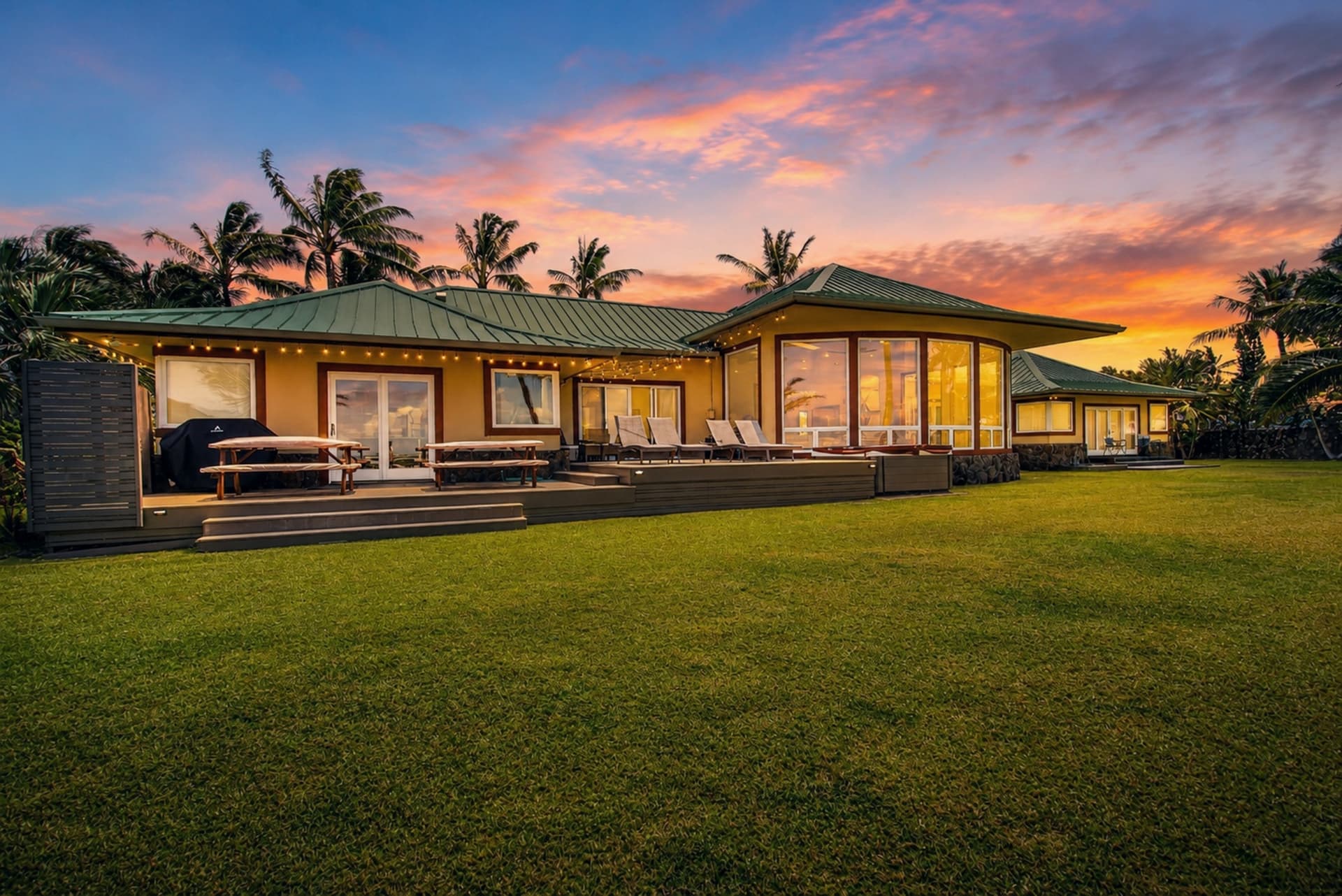 Wide virtual twilight view of an Oahu estate beneath a colorful sunset