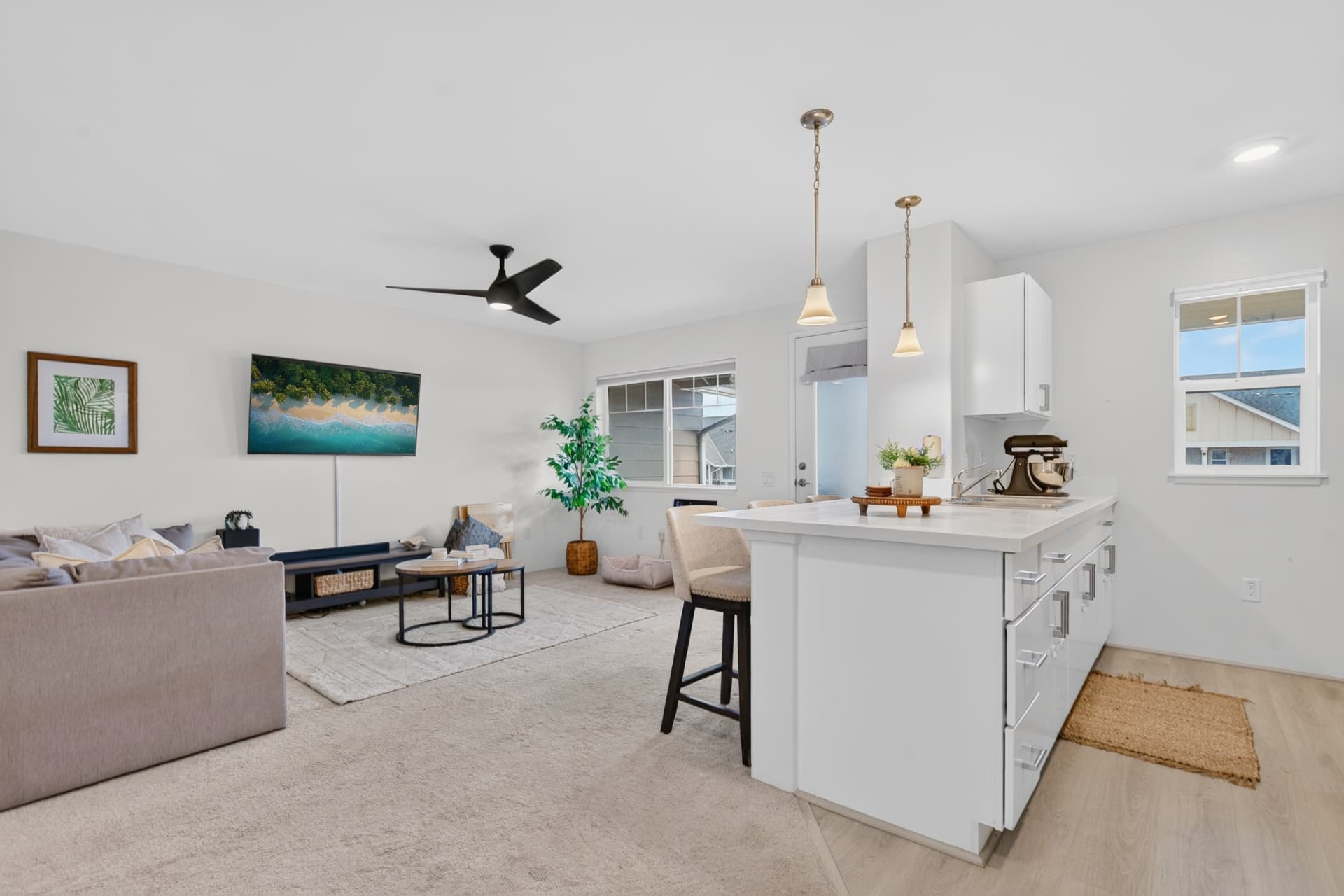 Bright modern Oahu kitchen and living room with clean neutral finishes